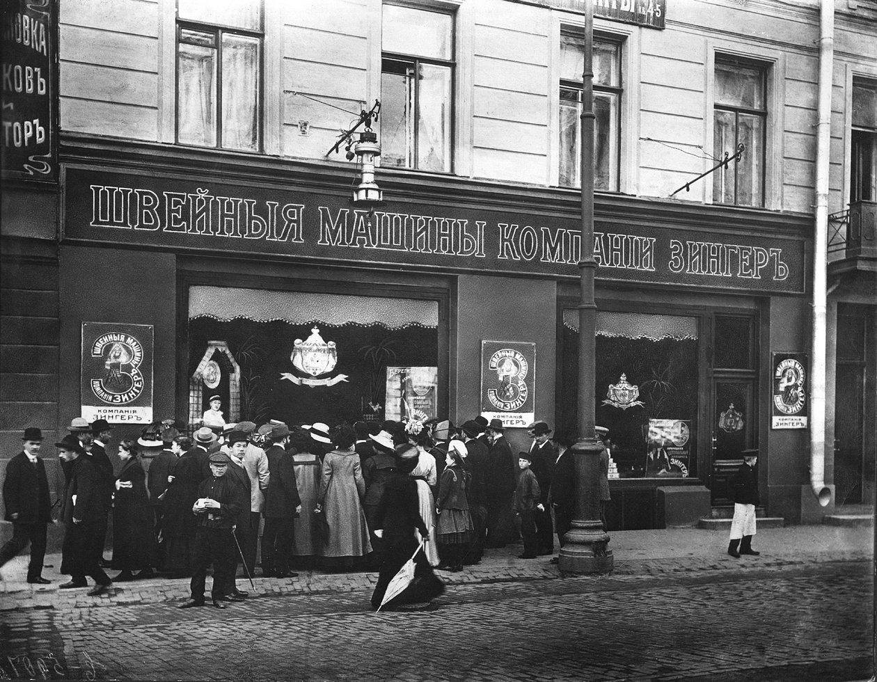 Multidões desenhadas para uma demonstração na vitrine da loja de máquinas de costura Singer, São Petersburgo de Russian Photographer